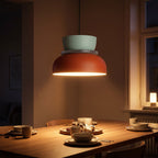 Two-Tone Stacked Metal Bowl Pendant Light above a dining table at night