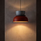 Two-Tone Stacked Metal Bowl Pendant Light glowing against a plaster wall at night