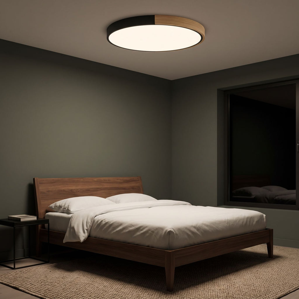 Black ultra thin LED oyster ceiling light as the only light in a bedroom at night