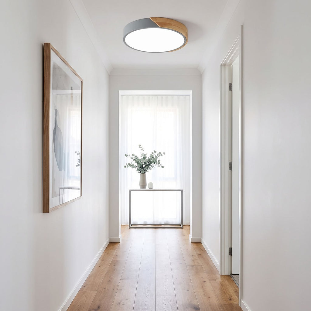 Grey ultra thin LED oyster ceiling light seen down the length of a hallway