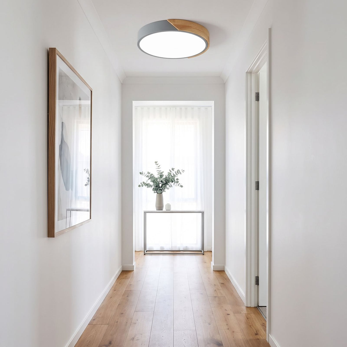 Grey ultra thin LED oyster ceiling light seen down the length of a hallway