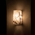Veined Marble Block LED Wall Light glowing on a plaster wall at night