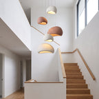 A cluster of Wabi Sabi Fibreglass Resin Pendant Lights in white and terracotta at staggered heights in a stairwell