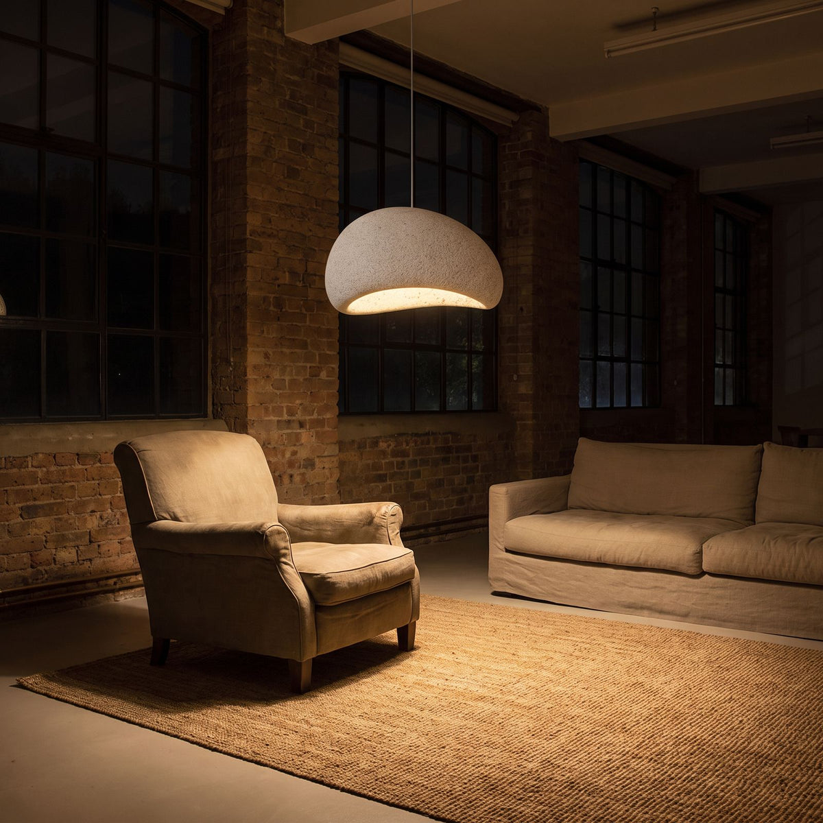 Wabi Sabi Fibreglass Resin Pendant Light in white, Ø40 cm, over a reading armchair in a living room at night