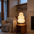 Wabi-Sabi Rice Paper Tripod Table Lamp beside a reading armchair