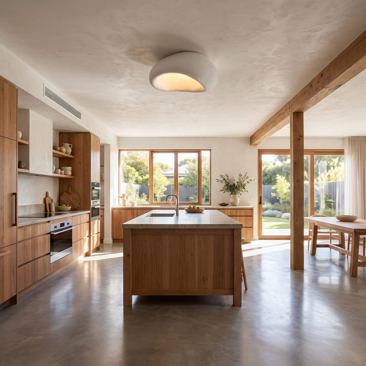 Wabi-sabi textured pebble ceiling light in a wide living room view
