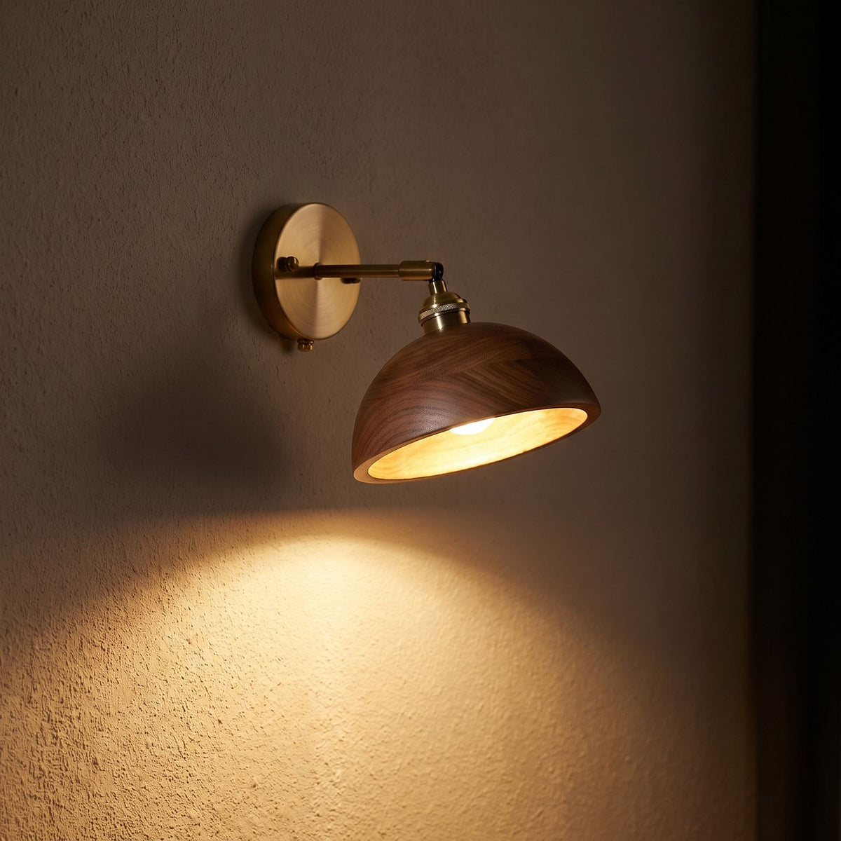 Walnut Dome Shade Pull Cord Wall Light glowing on a plaster wall at night