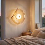 Wavy Art Glass Disc LED Wall Light beside a bed