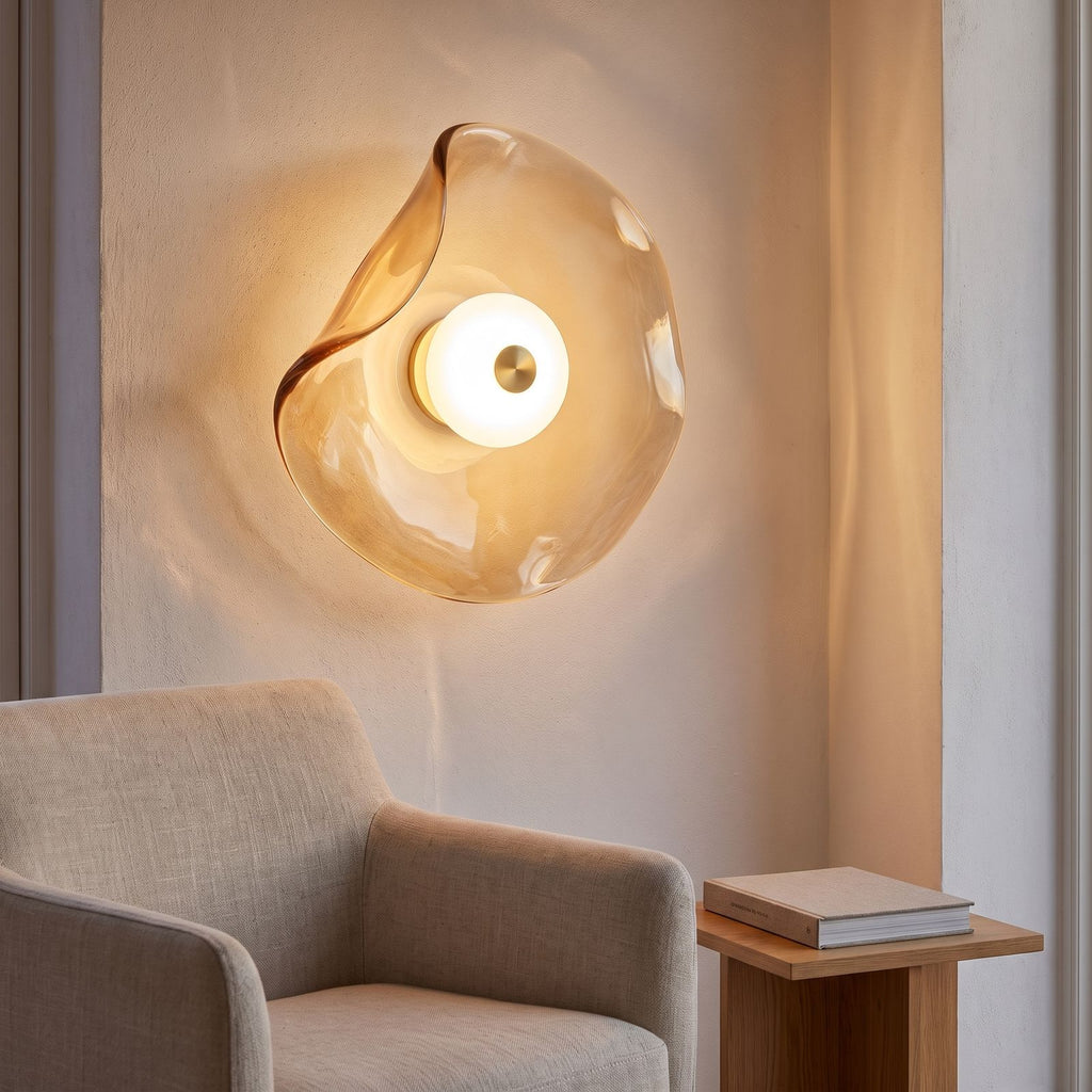 Wavy art glass disc wall light above an armchair in a reading corner