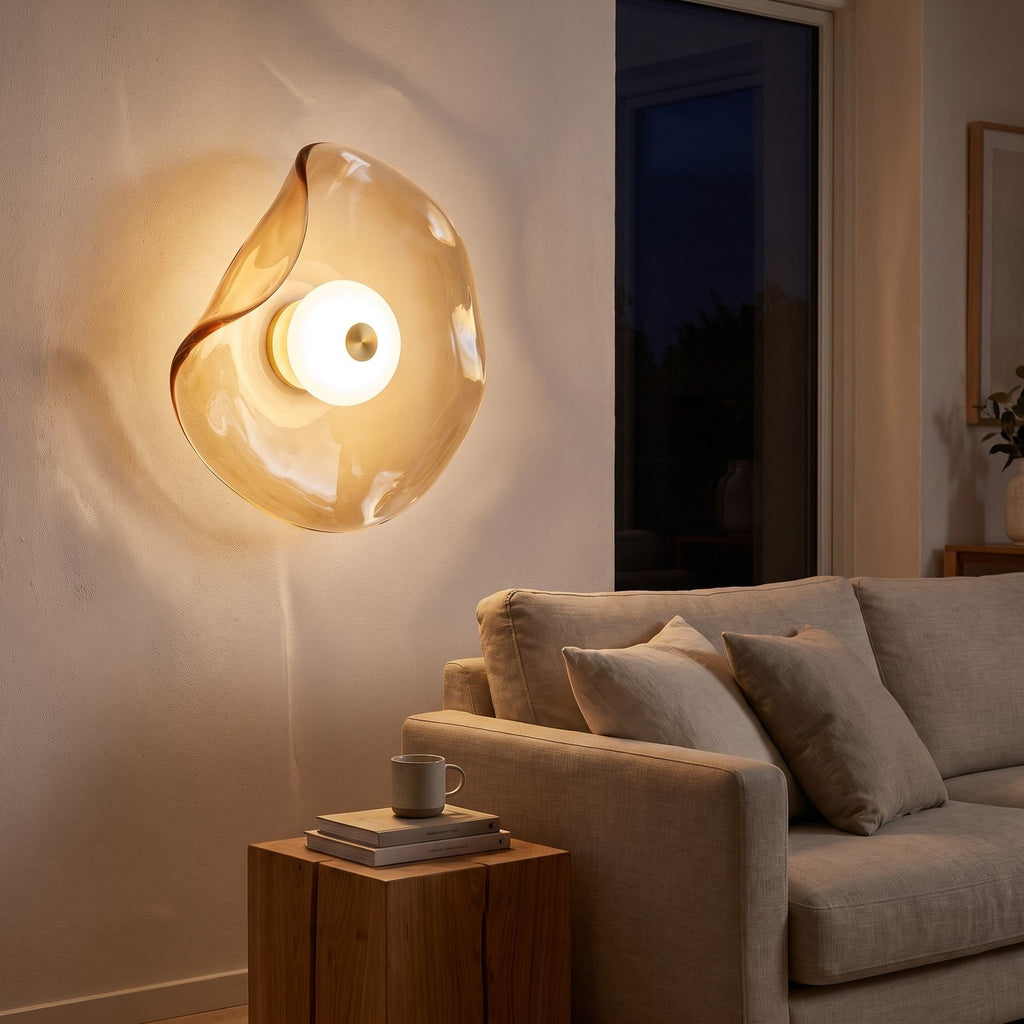 Wavy art glass disc wall light beside a living room sofa at night