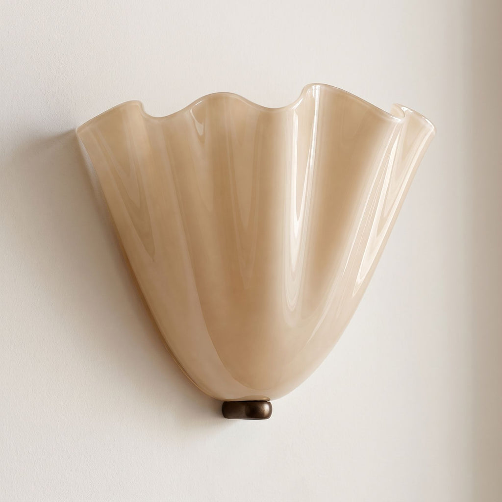 Wavy Beige Glass Shell Wall Light on a plaster wall in daylight