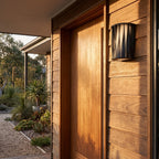 Wavy Openwork Stainless Steel Outdoor Wall Light beside a timber front door