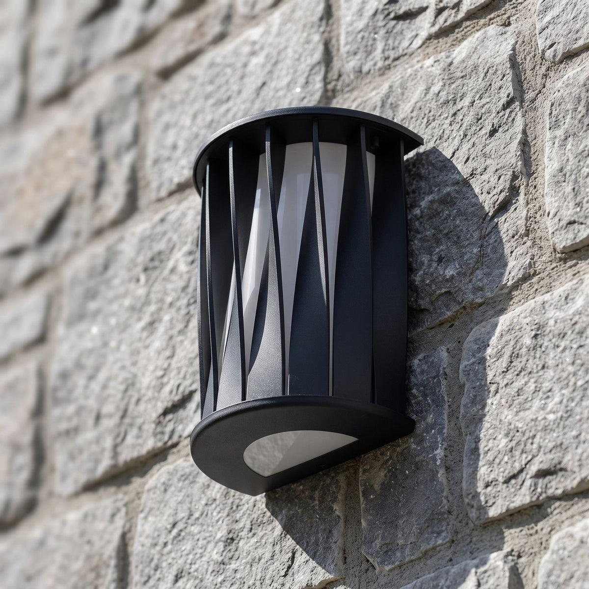Wavy Openwork Stainless Steel Outdoor Wall Light, close view at 45 degrees on a stone wall
