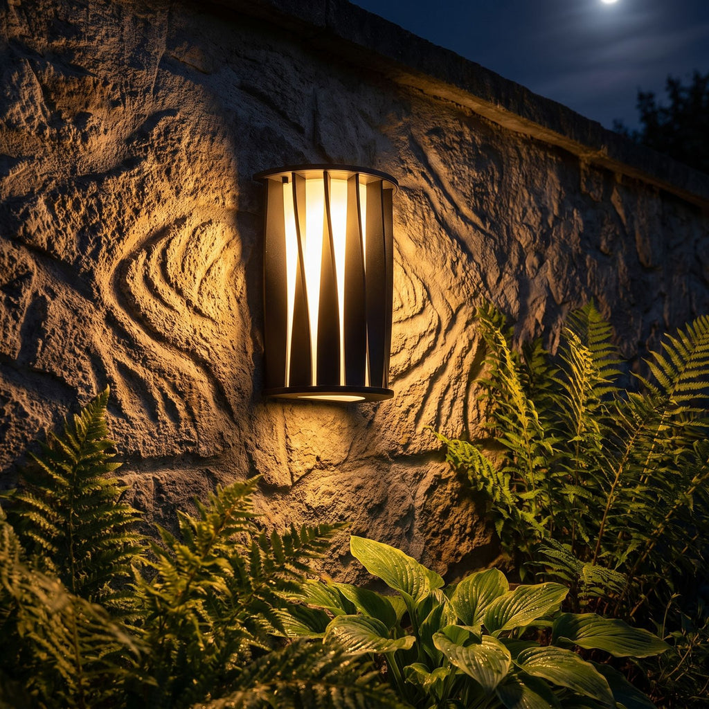 Wavy Openwork Stainless Steel Outdoor Wall Light glowing on a garden wall at night