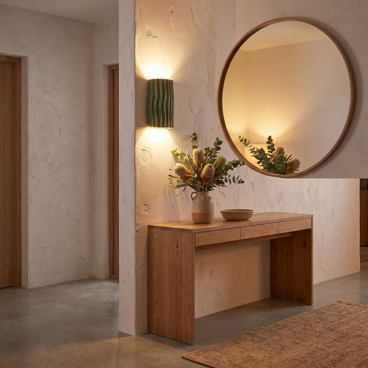 Wavy ribbed resin up down wall light beside a round mirror in an entry hall