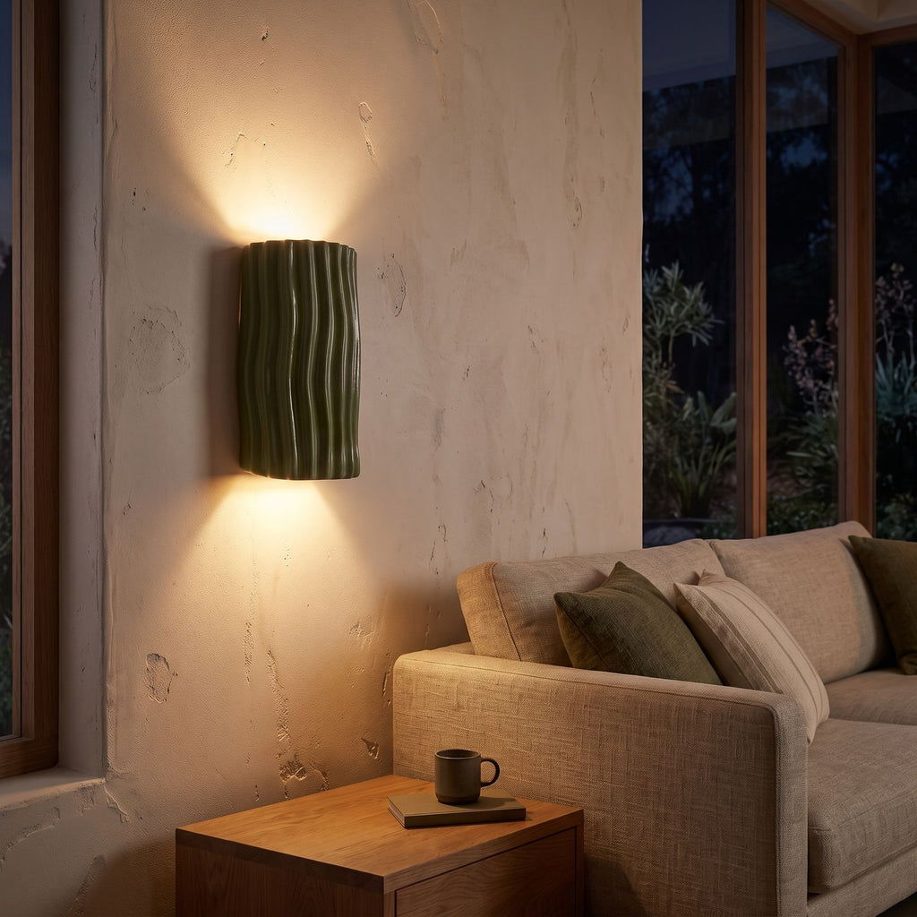 Wavy ribbed resin up down wall light beside a living room sofa at night