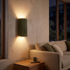 Wavy ribbed resin up down wall light beside a living room sofa at night
