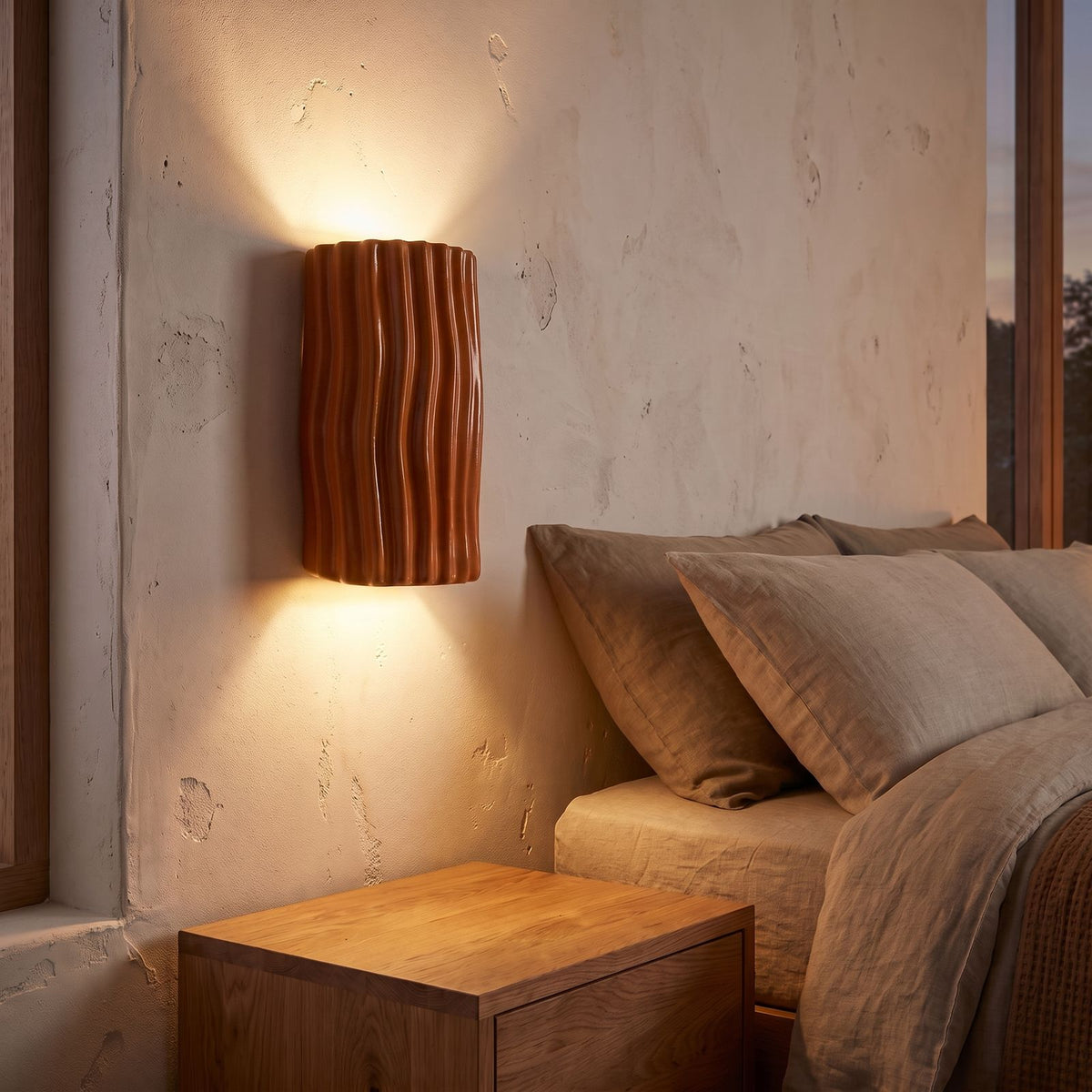 Wavy Ribbed Resin Half Cylinder Up Down Wall Light in orange beside a bed