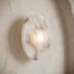 White Alabaster Halo Wall Light, close view at 45 degrees on a plaster wall