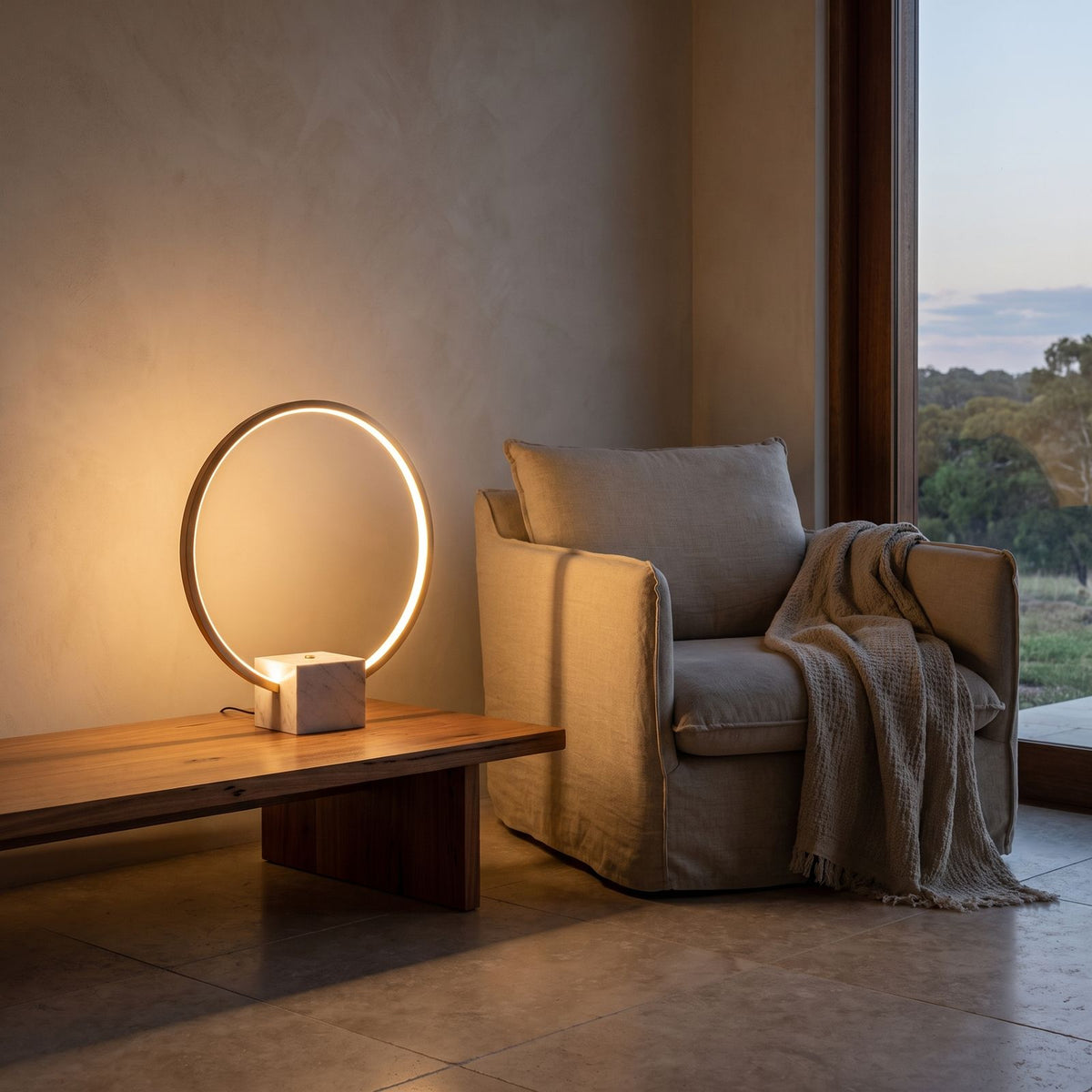 White Marble and Copper LED Table Lamp beside a reading armchair