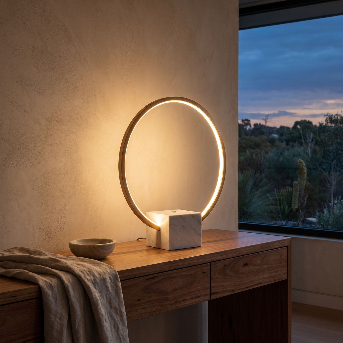 White Marble and Copper LED Table Lamp glowing on a timber console at dusk