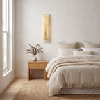 Wide Alabaster Panel Brass Wall Light on a bedroom wall beside the bed