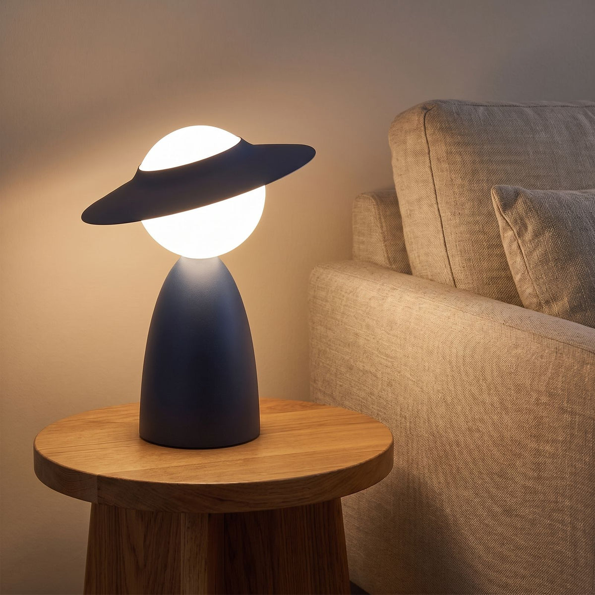Wide brim hat glass globe table lamp on a side table beside a sofa