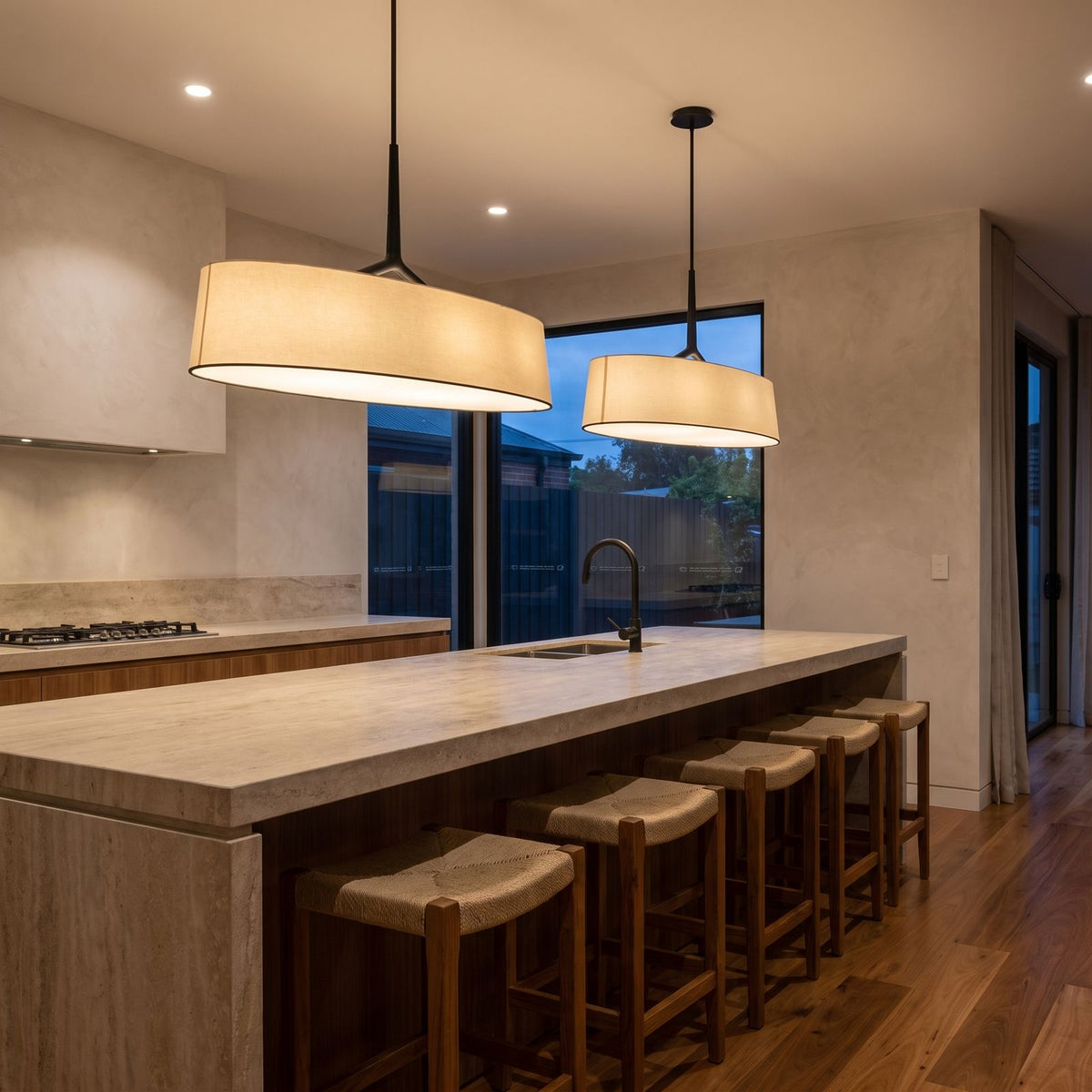 A pair of Wide Fabric Drum LED Pendant Lights over a stone kitchen island