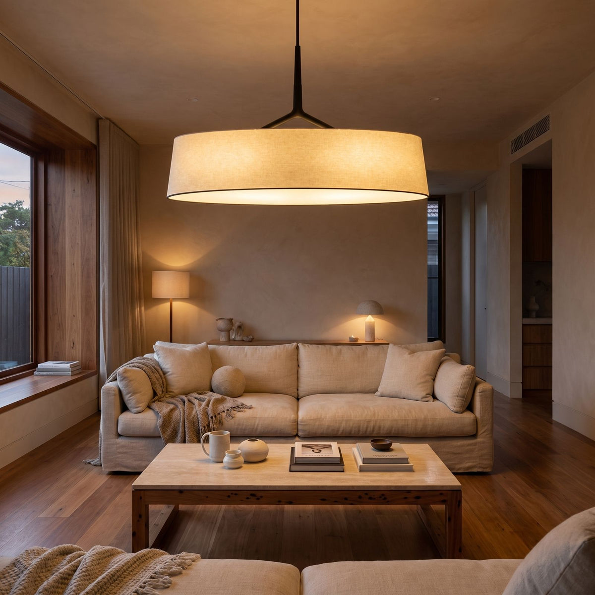 Wide Fabric Drum LED Pendant Light above a linen sofa in a living room