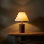 Wood Base Cone Shade Bedside Table Lamp glowing on a timber console at night