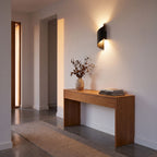 Wrap Around Aluminium and Glass Up Down Wall Light in a hallway above a timber console